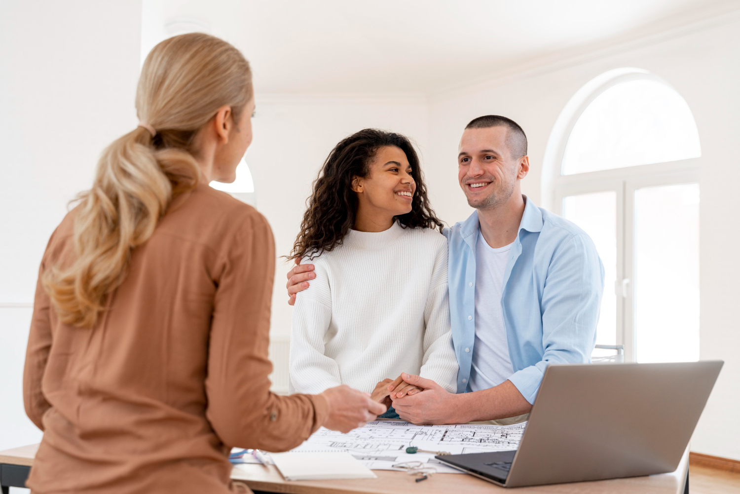 Mortgage broker using mortgage presentation software with clients at a desk.